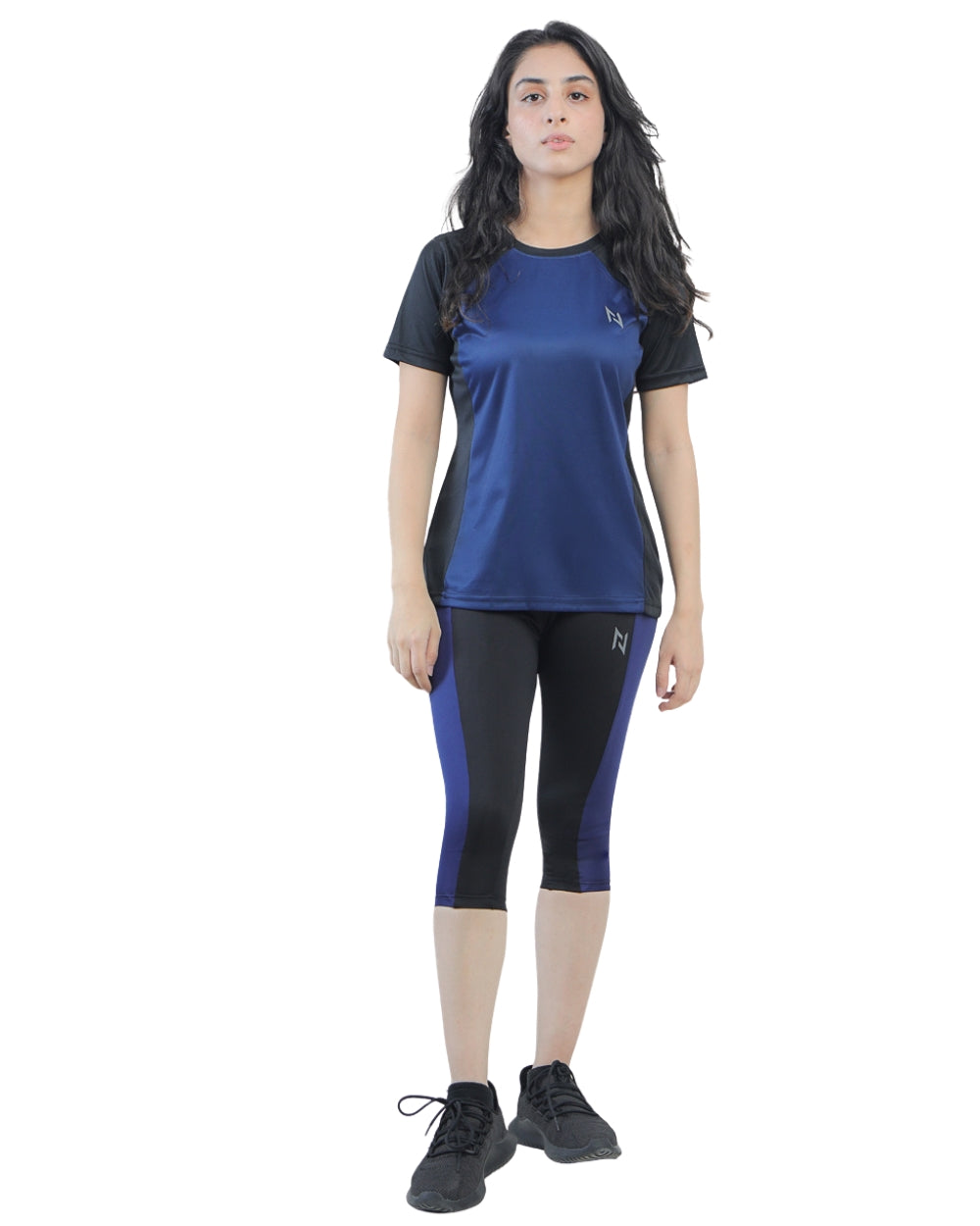 Woman wearing a blue athletic top and black leggings on a white background