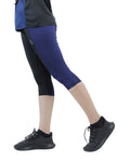 Person wearing blue athletic leggings and black sneakers on a white background