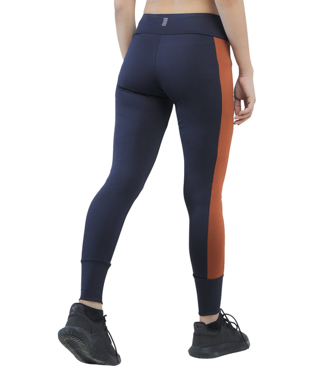 Navy leggings with orange stripe worn by a person on a white background